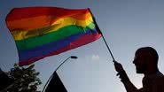 Pessoa segurando bandeira do orgulho LGBTQIAP+ - Getty Images