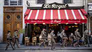 Militares franceses passando em frente a um restaurante em Paris - Getty Images