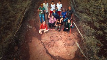 Equipe de pesquisadores ao lado das pegadas de dinossauros - Divulgação