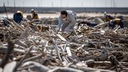 Homem fazendo buscas em destroços provenientes do tsunami de 2011 no Japão - Getty Images