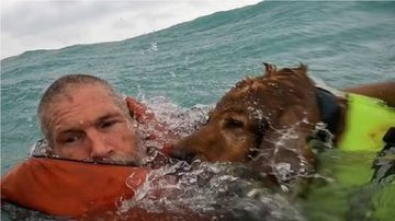 Homem e cachorro no momento do resgate. - U.S Coast Guard