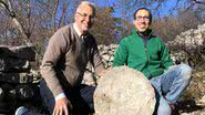 Paolo e Federico, dupla responsável pelo achado, posa com pedra perfurada com mapa de estrelas - Divulgação / Instituto Nacional Italiano de Astrofísica