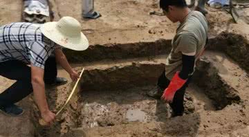 Arqueólogos medem uma das covas encontradas próximas ao rio - Divulgação