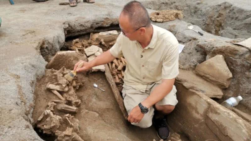 Pesquisador analisando tumba em Lijiang, China - Divulgação/Yunnan Daily