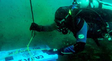 Mergulhador devolvendo os artefatos ao mar - Instituto Nacional de Antropologia e História