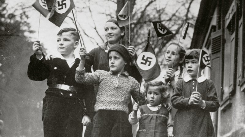 Crianças alemãs com bandeiras nazistas - Getty images