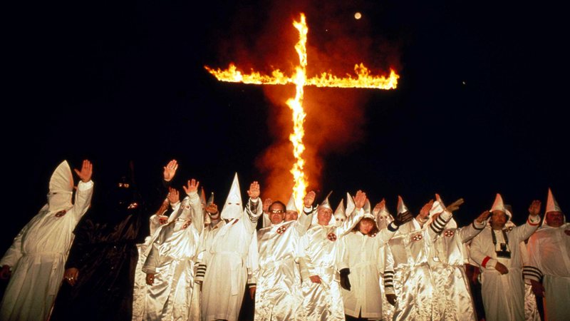 Membros da Klu Klux Klan queimando uma cruz - Getty Images