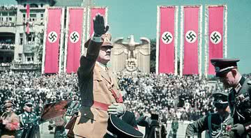 Hitler saudando seus membros, cercado por símbolos nazistas - Getty Images