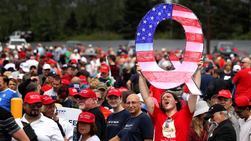 Membro do QAnon segurando um 'Q' enorme em evento pró-Trump em 2018 - Getty Images