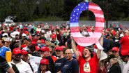 Membro do QAnon segurando um 'Q' enorme em evento pró-Trump em 2018 - Getty Images