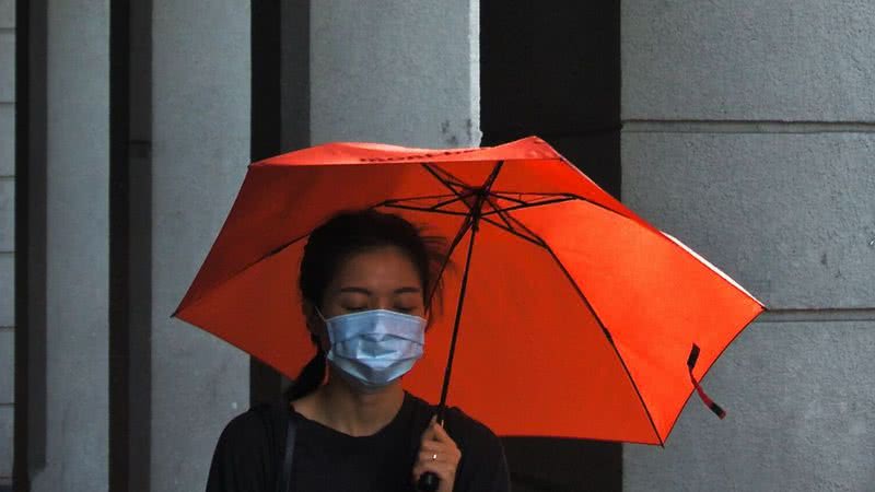 Imagem ilustrativa de uma mulher usando máscara na rua - Unsplash