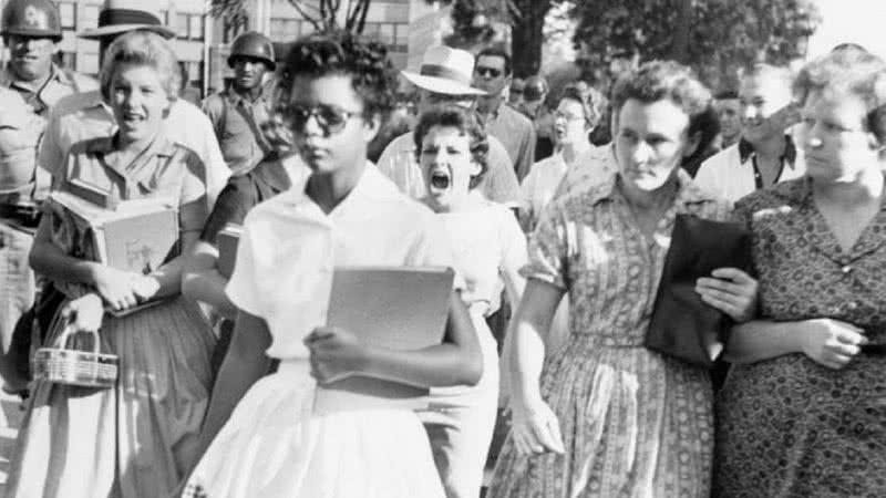 Elizabeth Eckford caminhando para Little Rock Central High School, enquanto Hazel Bryan está atrás dela gritando - Wikimedia Commons