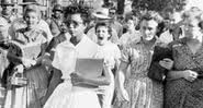 Elizabeth Eckford caminhando para Little Rock Central High School, enquanto Hazel Bryan está atrás dela gritando - Wikimedia Commons