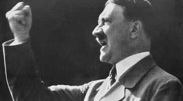 Adolf Hitler levanta um punho desafiador e cerrado durante um discurso - Getty Images