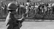 Um soldado do Exército chileno vigia prisioneiros políticos mantidos no Estádio Nacional de Santiago - Getty Images