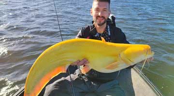 O pescador segurando o bagre amarelo - Divulgação/Martin Glatz