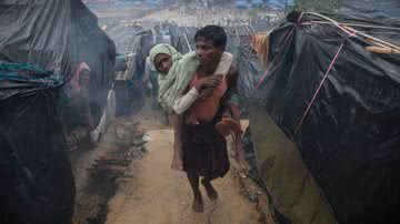 Homem rohingya carrega sua mãe deficiente no campo de refugiados de Cox's Bazar, no Bangladesh, em 2017 - Paula Bronstein/Getty Images