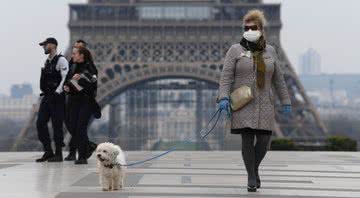 Imagem ilustra visitantes de máscara próximos a Torre Eiffel - Getty Images