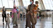 Família afegã caminha em aeroporto - Getty Images