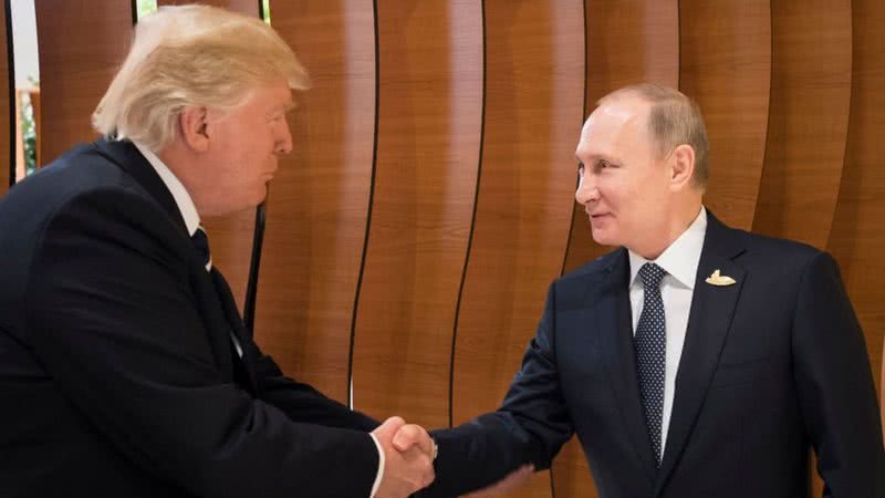 Putin e Trump apertam as mãos - Getty Images