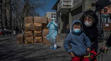 Criança acompanhada de adultos na China - Getty Images