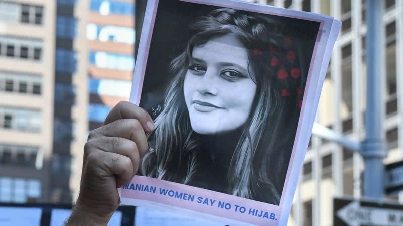 Cartaz com o rosto de Mahsa Amini com a frase "mulheres iranianas dizem não ao hijab" - Getty Images