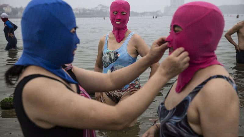 Mulheres usando 'facekinis' em uma praia - Getty Images