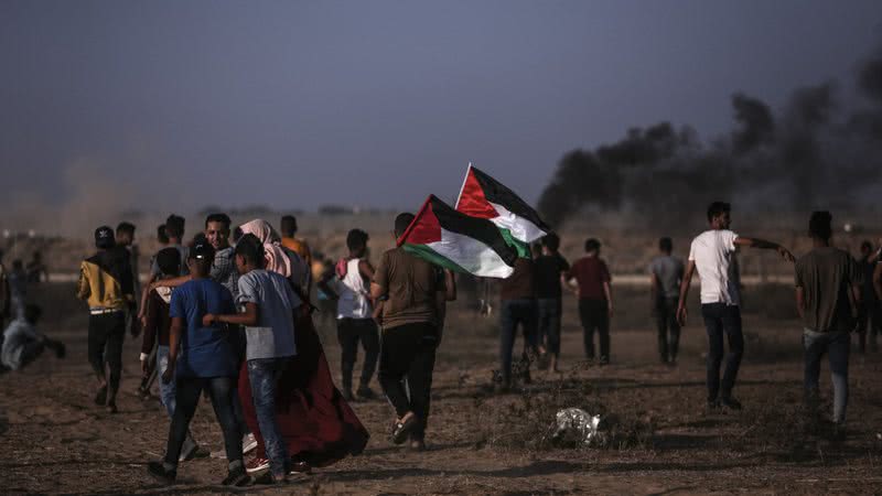 Manifestantes palestinos se reúnem perto da fronteira da Faixa de Gaza com Israel durante uma manifestação - Getty Images