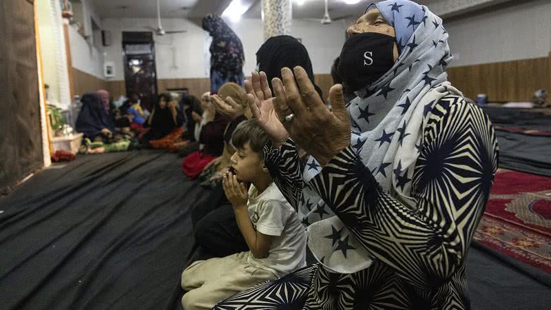 Mulheres e crianças afegãs rezam em uma mesquita - Getty Images