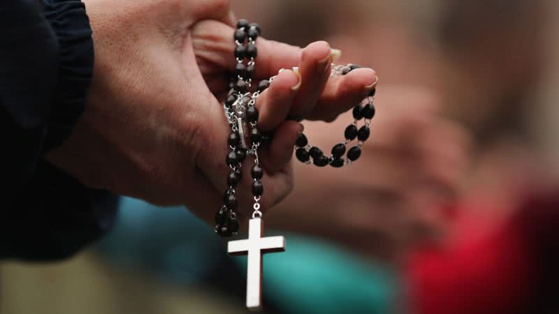 Um fiel segura um terço - Getty Images