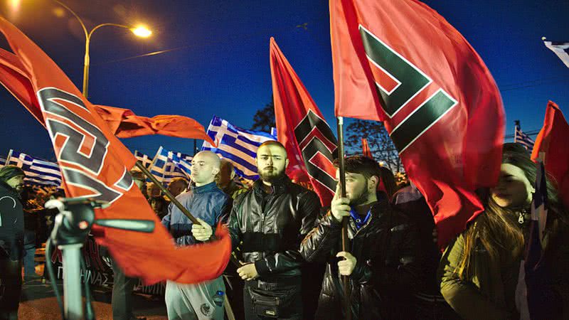 Membros do Golden Dawn com bandeira do partido em manifestação em 2015 - Wikimedia Commons