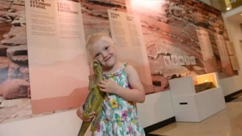 Lily com dinossauro de brinquedo no Museu - Divulgação / Museu Nacional de Cardiff