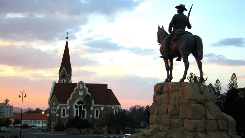 Igreja alemã, ao lado de monumento de colono, em Windhoek, capital da Namíbia - Wikimedia Commons