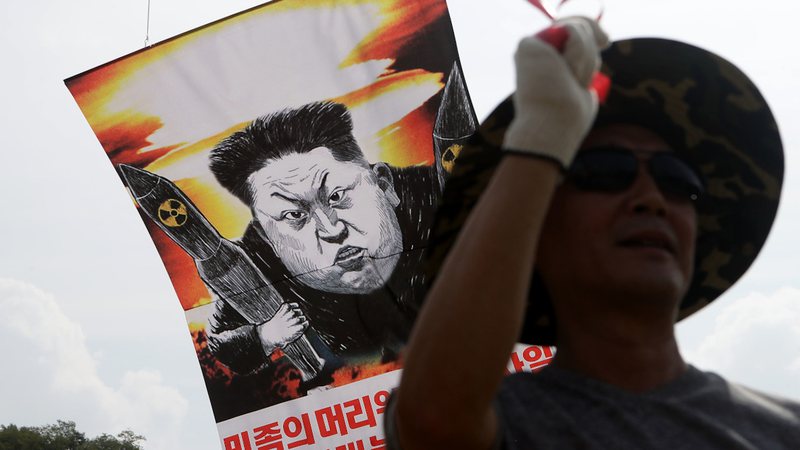 Manifestante carregando um cartaz representando Kim Jong-un, Líder Supremo da Coreia do Norte - Getty Images