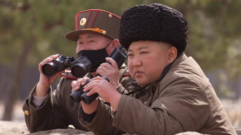 Kim e um oficial, que usa a máscara contra o corona - KCNA