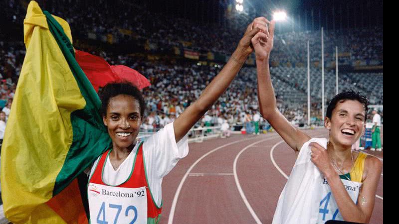 Bicampeã no atletismo, a etíope Derartu Tulu, à esq., celebra a vitória com a prata sul-africana Elana Meyer em Barcelona, 1992 - Pascal PAVANI / AFP