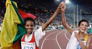 Bicampeã no atletismo, a etíope Derartu Tulu, à esq., celebra a vitória com a prata sul-africana Elana Meyer em Barcelona, 1992 - Pascal PAVANI / AFP