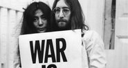 Yoko Ono e John Lennon com cartaz pedindo a paz - Getty Images