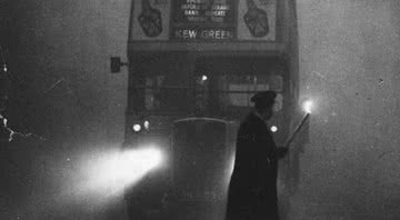 Homem usa uma tocha para guiar um ônibus durante o Grande Nevoeiro de 1952 - Monty Fresco/ Getty Images