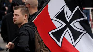 Homem segurando bandeira do antigo Império Alemão, durante evento na Alemanha - Getty Images