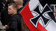 Homem segurando bandeira do antigo Império Alemão, durante evento na Alemanha - Getty Images