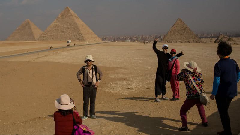 Turistas tirando fotografias na frente das pirâmides de Guizé em 2016 - Getty Images