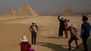 Turistas tirando fotografias na frente das pirâmides de Guizé em 2016 - Getty Images