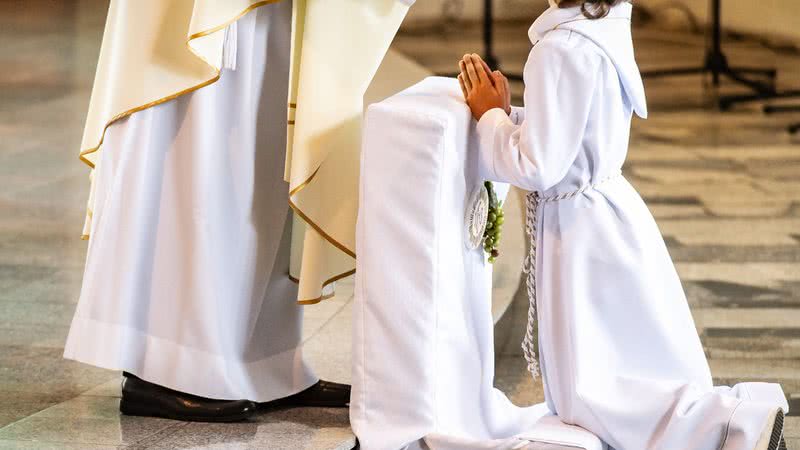 Imagem ilustrativa de um padre e uma criança - Getty Images