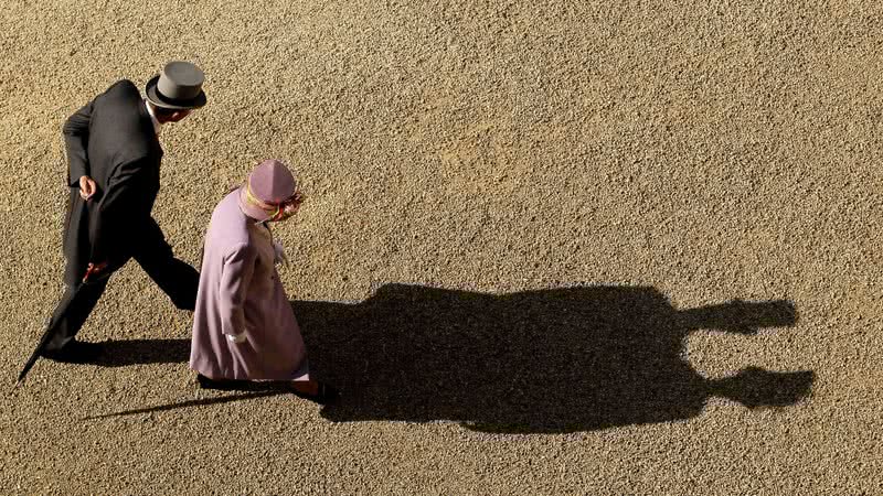 Príncipe Philip e rainha Elizabeth II caminhando juntos, com suas sombras unidas - Getty Images