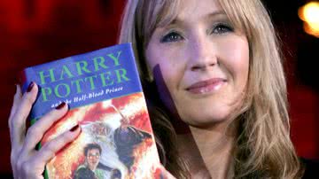 J.K. Rowling ao lado de um exemplar de 'Harry Potter' - Getty Images