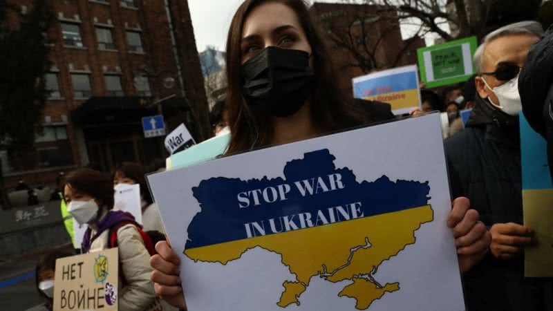 Mulher segura cartaz contra a guerra - Getty Images