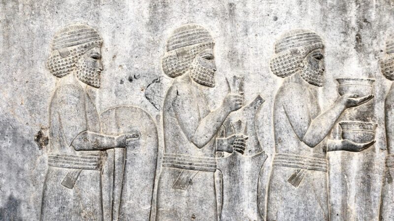 Foto ilustrativa de escultura assíria com 3 homens ligados à realeza