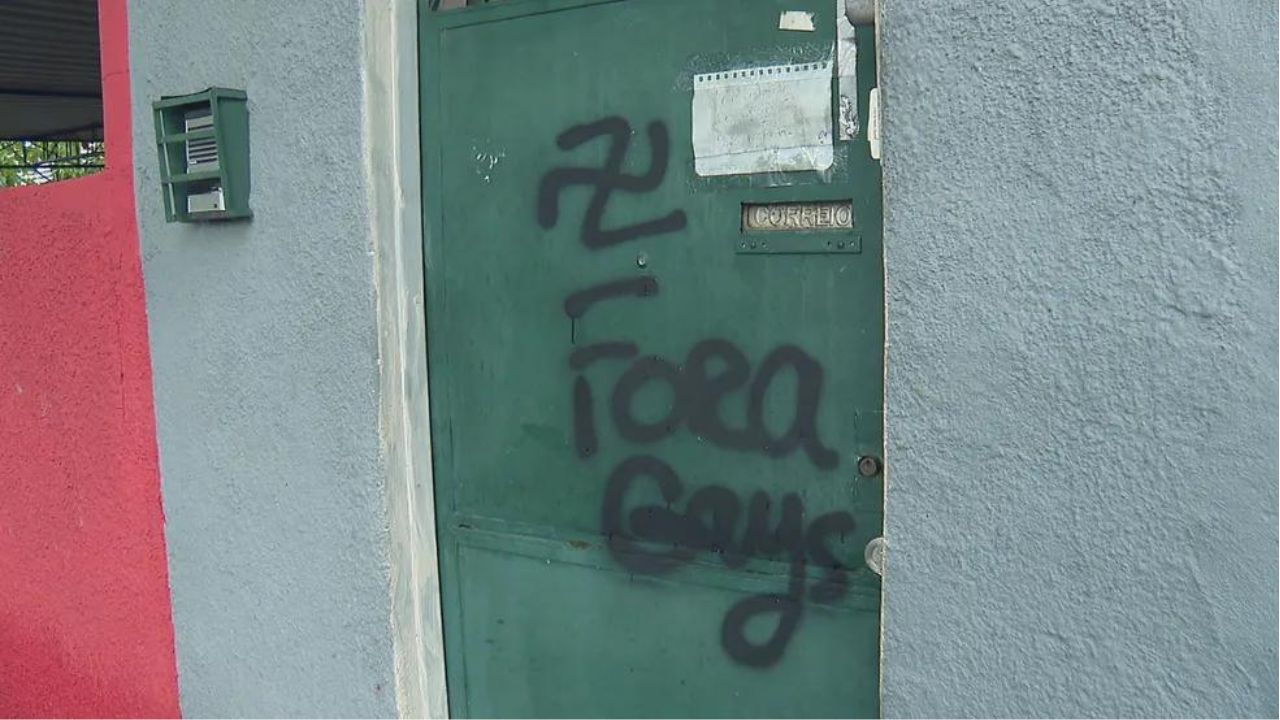 Casal gay tem portão de residência pichado com suástica nazista e frase homofóbica