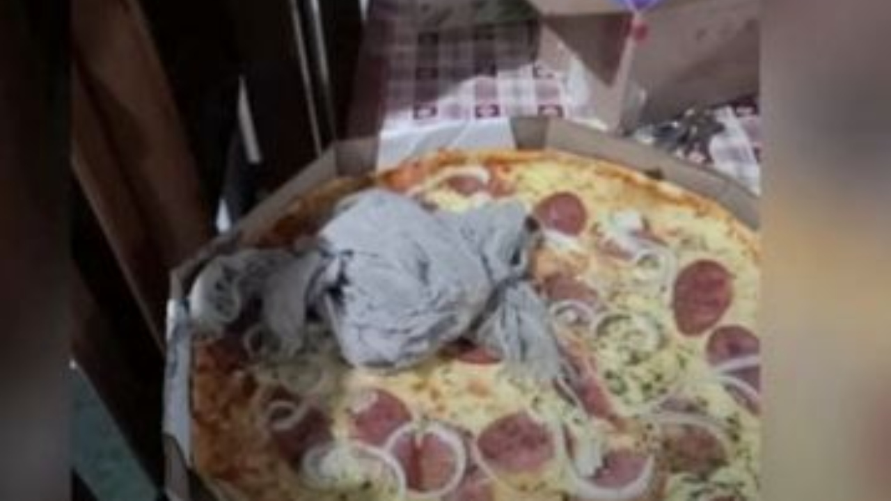 Bar entrega pizza com pano de chão sujo dentro da caixa